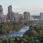 Condo towers in Eau Claire rise above the Bow River and the red Peace Bridge in Calgary