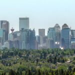 Downtown Calgary skyline seen from the northwest above a canopy of trees